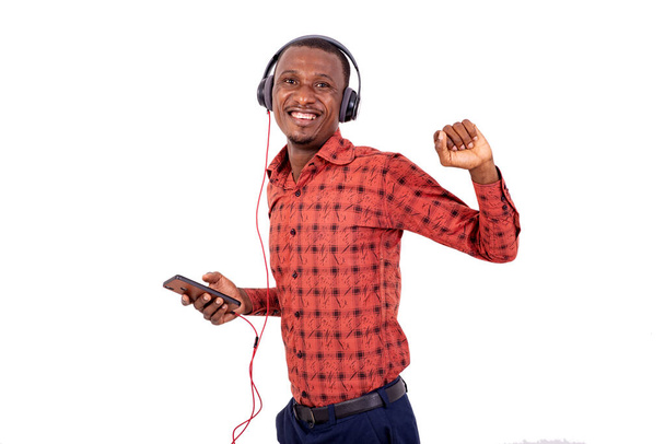 портрет молодого бізнесмена, який слухає музику з гарнітурою на мобільному телефоні, посміхаючись
. - Фото, зображення