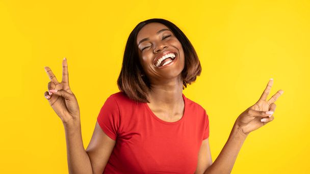 Happy Black Lady Gesturing Victoire avec les deux mains, fond jaune - Photo, image