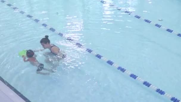 visão de alto ângulo da aula de natação no treinador de piscina ensina o menino a nadar - Filmagem, Vídeo