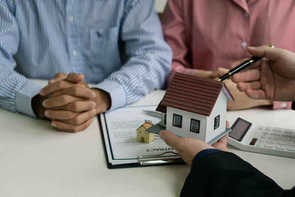 Le représentant des ventes propose un contrat d'achat d'une maison ou d'un appartement pour discuter des taux d'intérêt et de prêt, des idées d'affaires immobilières. - Photo, image