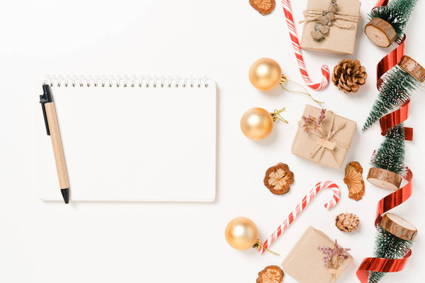 Minimal creative flat lay of winter christmas traditional composition and new year holiday season. Top view open mockup black notebook for text on white background. Mock up and copy space photography. - Φωτογραφία, εικόνα