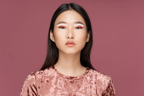 Nainen aasialainen ulkonäkö kirkas meikki ylellinen vaaleanpunainen tausta - Valokuva, kuva