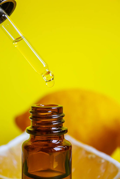 лимонна ефірна олія на жовтому фоні. Вибірковий фокус. назви
 - Фото, зображення