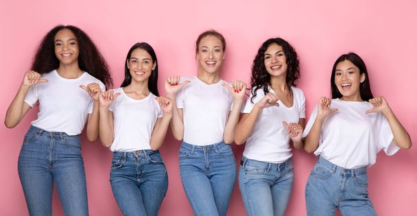 Pięć wieloetnicznych kobiet wskazujących na siebie kciukami, różowe tło, panorama - Zdjęcie, obraz