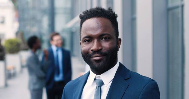 Portrait view of the confident multiracial man wearing formal clothes achieving business success and standing while smiling to the camera - Photo, image
