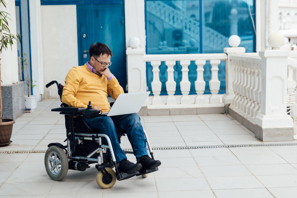 człowiek niepełnosprawny na wózku inwalidzkim pracuje przy komputerze w Internecie - Zdjęcie, obraz