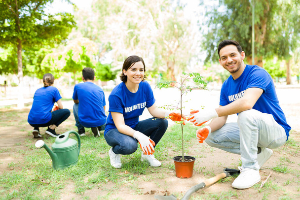 Ekologická komunitní práce. Šťastní latinskoameričtí přátelé, kteří společně vysázejí stromek v parku pro svou dobrovolnickou práci  - Fotografie, Obrázek