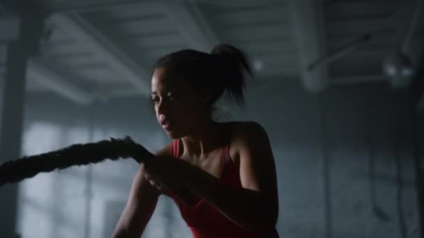 Starke Sportlerin kämpft im Fitnessstudio gegen Seile. Frau mit Sportgerät  - Filmmaterial, Video
