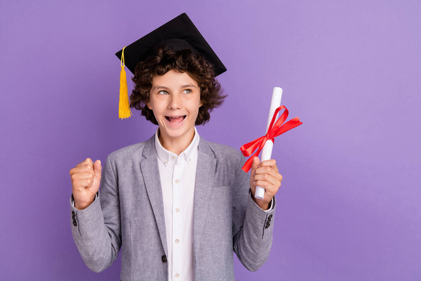 Photo of amazed triumphant schoolkid hold diploma look empty space wear hat grey suit isolated violet color background - Φωτογραφία, εικόνα