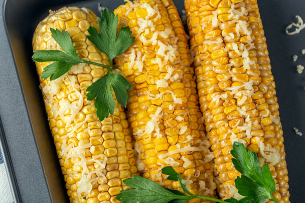 Recipe homemade cooking. Mexican Elote Corn sprinkled with cheese or parmesan and cilantro on baking sheet. Close up - Fotoğraf, Görsel
