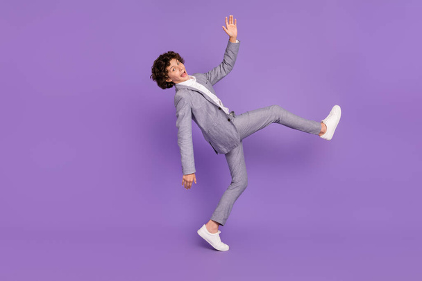Photo of careless crazy schoolboy guy disco dance fooling around wear grey suit isolated violet color background - Foto, Imagem