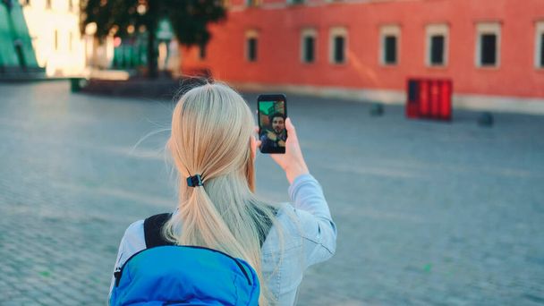Vrouwelijke toerist maakt video call op smartphone met haar vriend van andere plaats - Foto, afbeelding