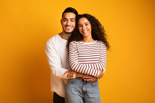 明るい若いアラブのカップルの肖像｜カメラで抱擁と笑顔 - 写真・画像