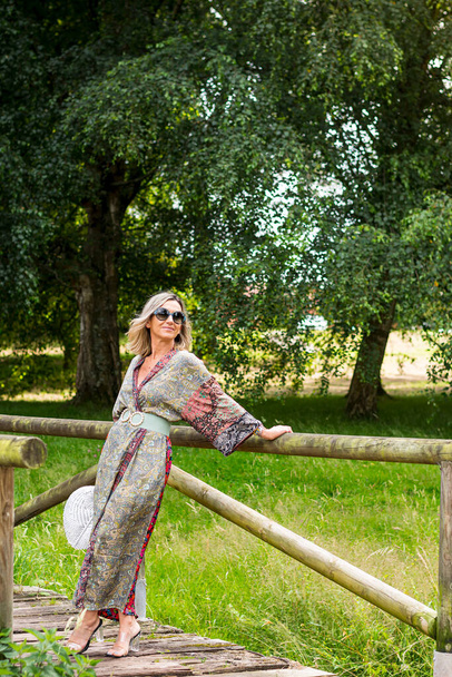 Mode-Fotosession in einem Park in Asturien, Spanien mit einem blonden Model. Das Foto wurde an einem sonnigen Tag im Hochformat aufgenommen. - Foto, Bild