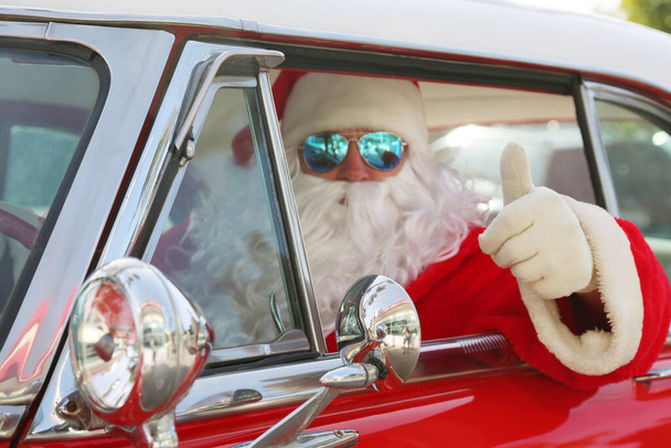 Weihnachten. Weihnachtsmann. Weihnachtsmannfahren. Hot Rod Auto. Der Weihnachtsmann fährt sein Hot-Rod-Auto. Der Weihnachtsmann fährt sein Auto. Der Weihnachtsmann kommt mit Stil. Santa Cruises in seinem Oldtimer. Der Weihnachtsmann fährt. Der Weihnachtsmann im Urlaub. Weihnachtsmann-Roadtrip. - Foto, Bild