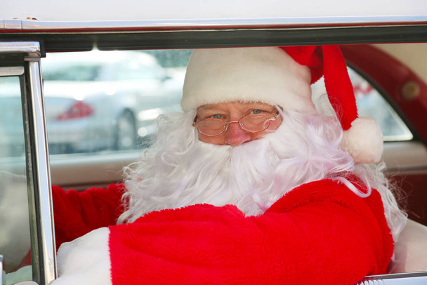 クリスマスだ。サンタクロース。サンタクロースの運転。ホットロッドカー。サンタクロースはホットロッドカーを運転する。サンタは車を運転する。サンタクロースがスタイルで到着します。クラシックカーのサンタクルーズ。サンタクロースが運転する。休暇でサンタクロース。サンタクロースロードトリップ. - 写真・画像