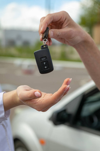 woman holding car keys and key - Фото, зображення