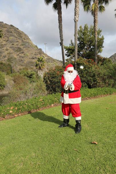 Christmas. Santa Claus. Golfing. Golf Game. Funny Santa Claus plays golf. Christmas Santa Claus plays golf. Santa Golf. Hipster Santa wears his Golf Hat. Santa Puts a Golf Ball. Santa Claus gets a Hole in One.  - Photo, Image