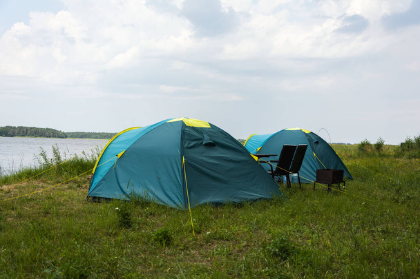 Tourist tents for camping on the lake shore, travel history. fishing, tourism, active recreation. Natural landscape. For lifestyle design. Outdoor recreation. - Foto, Imagen