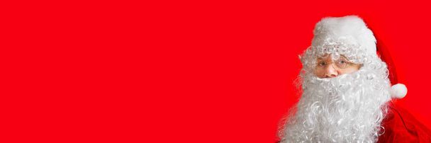 portret mężczyzny przebranego za Świętego Mikołaja na czerwonym tle - Zdjęcie, obraz