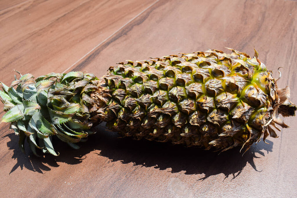 Pineapple fruit. Sweet delicious fruits with wooden background. top view of pineapple - Photo, Image