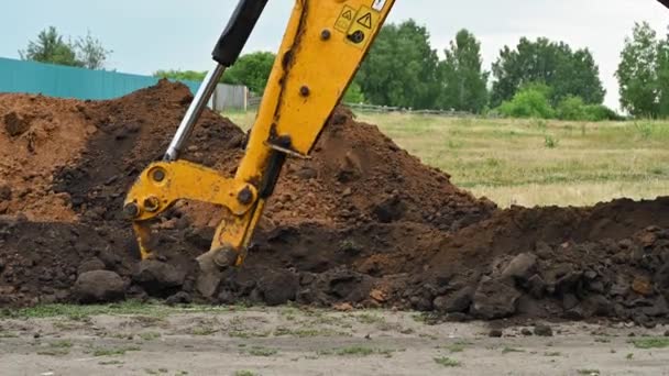Primer plano de una excavadora cavando una zanja profunda - Metraje, vídeo