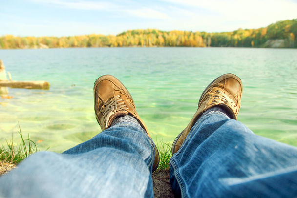 man feet in shoes near the lake - Photo, image
