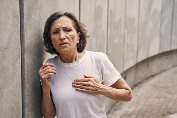 Active aged woman having heart attack outdoors - Foto, Imagem