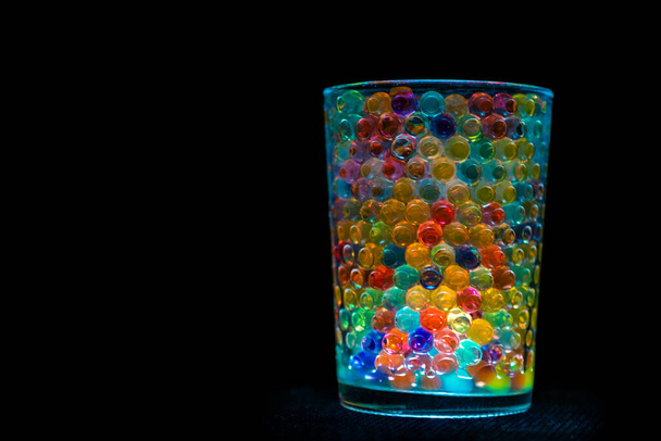 multicolored balls inside a transparent and illuminated container, giving a beautiful multicolored image. - Photo, Image