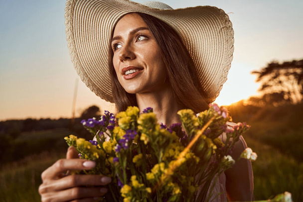 Ονειρεμένο άτομο που χαλαρώνει στη φύση με όμορφα λουλούδια - Φωτογραφία, εικόνα