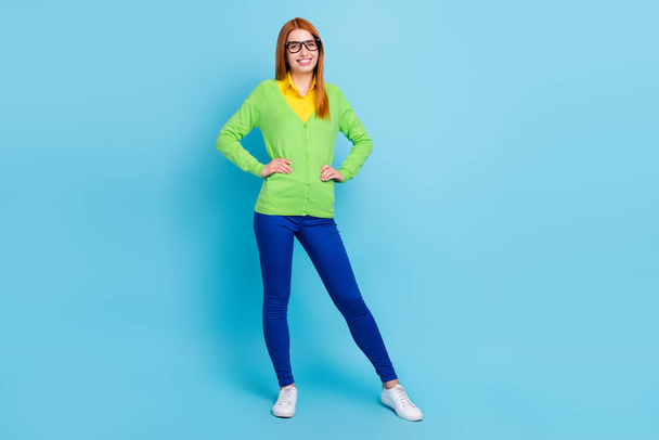 Full size photo of agent young lady wear green sweater trousers sneakers isolated on blue color background - Foto, Imagen