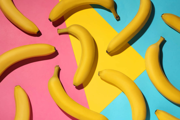 Ripe yellow bananas on color background, flat lay - Valokuva, kuva
