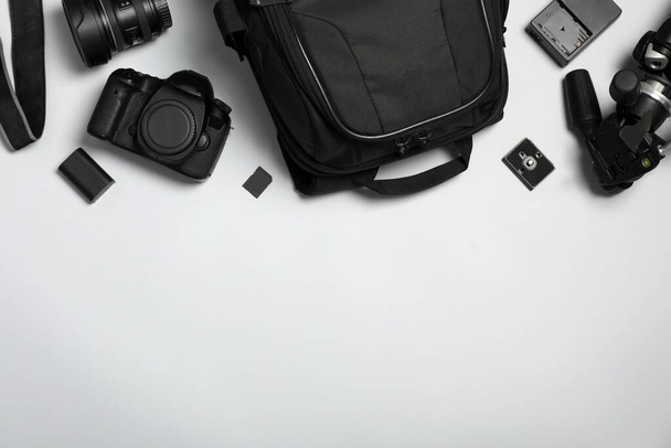 Professional photography equipment and backpack on grey background, flat lay. Space for text - Fotoğraf, Görsel