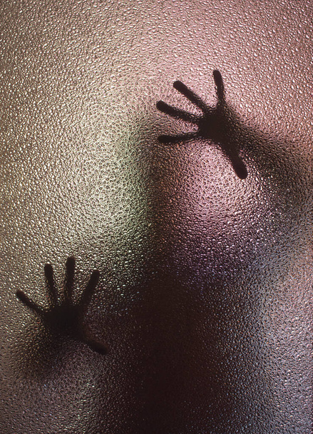las sombras de las manos a través del vidrio esmerilado en luz rosa. Foto de alta calidad - Foto, Imagen