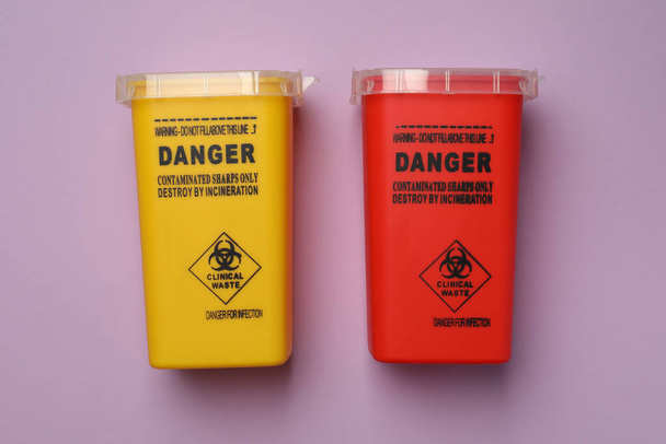 Sharps containers for used syringe on violet background, flat lay - Φωτογραφία, εικόνα