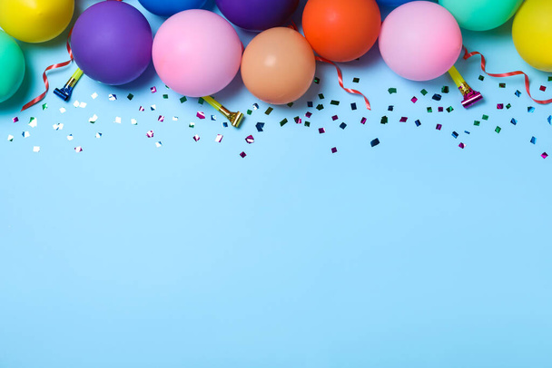 Flat lay composition with balloons and confetti on light blue background, space for text. Birthday decor - Фото, зображення