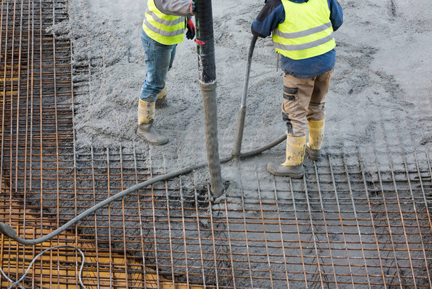 werknemers met betonnen pompbuis - Foto, afbeelding