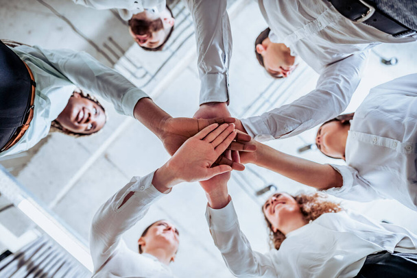 Underneath view, Business teamwork groups people hands, stacked huddle together, unity international. - 写真・画像