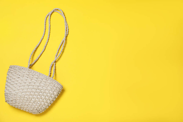 Stylish straw beach bag on yellow background, top view. Space for text - Photo, Image