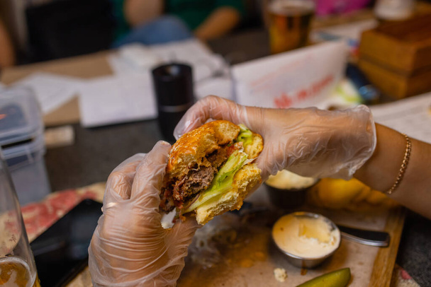 Close Up Of Female Hands Holding Delicious Bacon Burger. - Foto, afbeelding