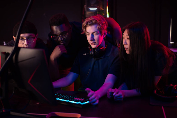 Players of the esports team gathered together in the computer club and watch the stream from the dota 2 world championship - 写真・画像