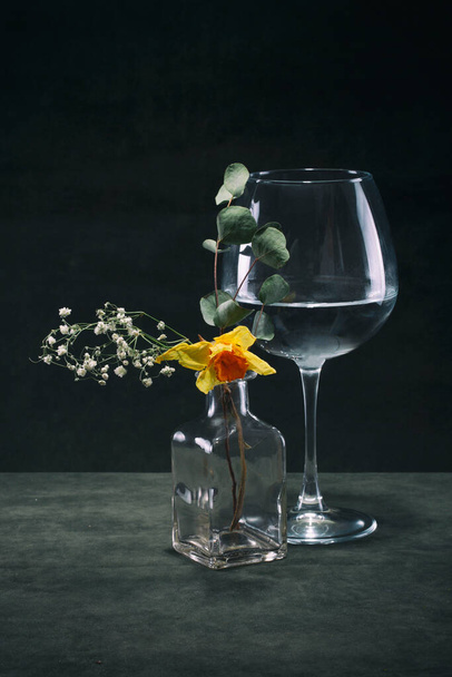 Νεκρή ζωή με ένα ποτήρι κρασί και ένα λουλούδι σε ένα γυάλινο βάζο - Φωτογραφία, εικόνα