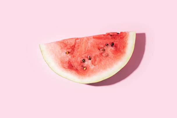 Kousek zralého melounu proti růžovému pozadí. - Fotografie, Obrázek