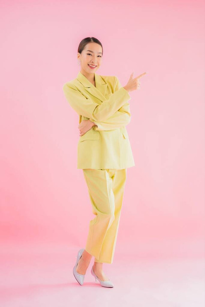 Portré gyönyörű fiatal ázsiai üzletasszony mosoly akcióban rózsaszín háttér - Fotó, kép