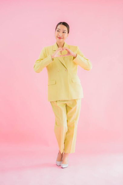Portret mooie jonge aziatische zakenvrouw glimlach in actie op roze kleur achtergrond - Foto, afbeelding