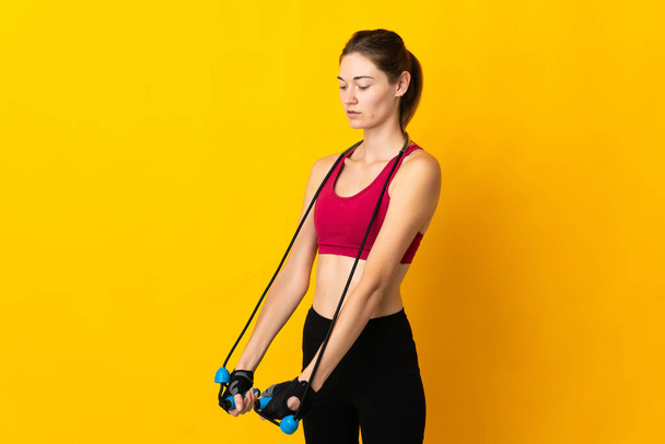 Young Ireland woman isolated on yellow background with jumping rope - Fotografie, Obrázek