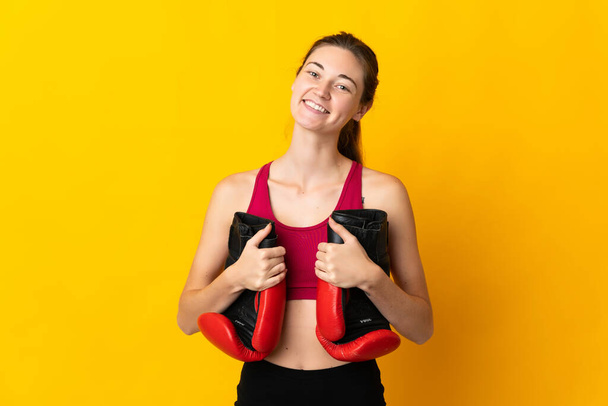 Young Ireland woman isolated on yellow background with boxing gloves - Фото, зображення