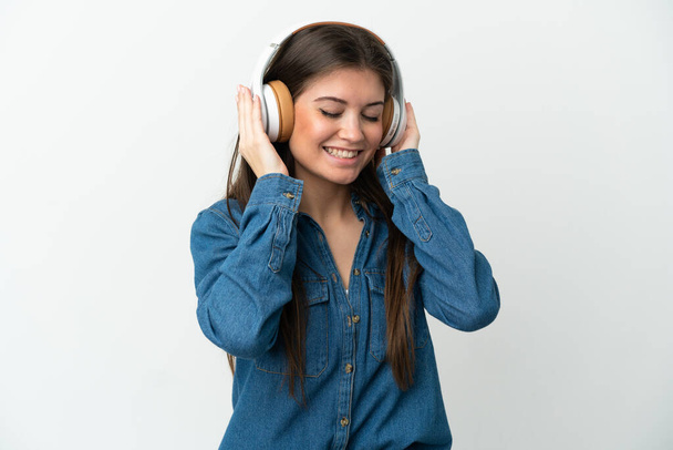 jonge Kaukasische vrouw geïsoleerd op witte achtergrond luisteren muziek - Foto, afbeelding