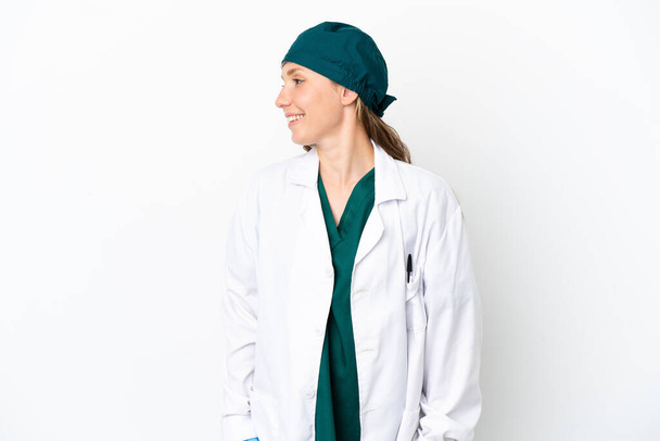 Chirurg blanke vrouw in groen uniform geïsoleerd op witte achtergrond uitziende kant - Foto, afbeelding