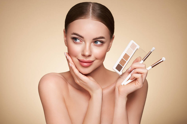 Beauty woman with eye shadow makeup palette. Model with healthy perfect skin, close up portrait. Cosmetology, beauty and spa - 写真・画像